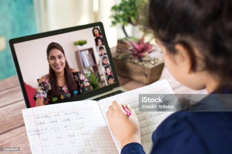 Girl participating in online education training class with teacher and other students using laptop at home